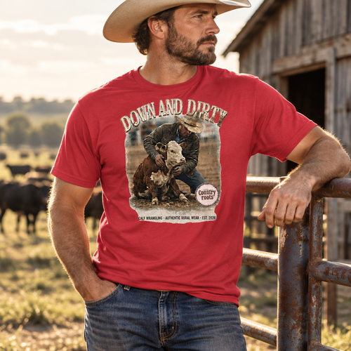 Cattle rancher wearing the Down and Dirty graphic T-shirt near a barn and pasture